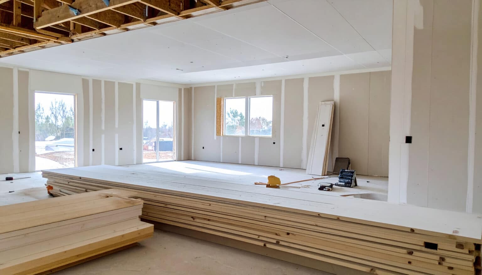 New construction project showcases stark beauty of drywall, revealing spacious interior with natural light. Drywall installation and repair in New London County, CT