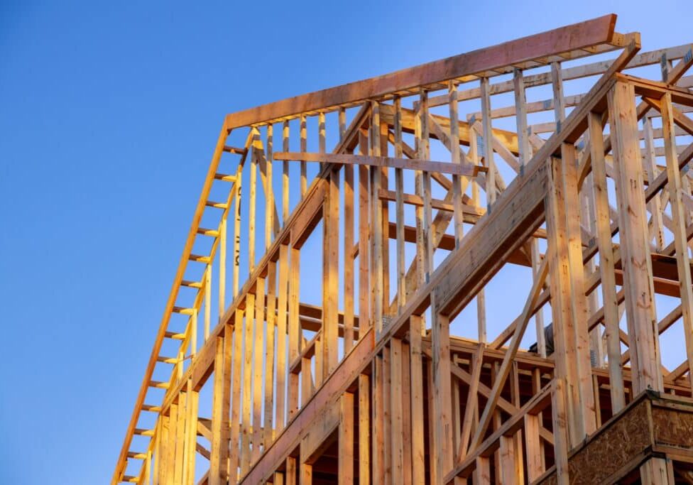 New residential construction home framing home against a blue sky